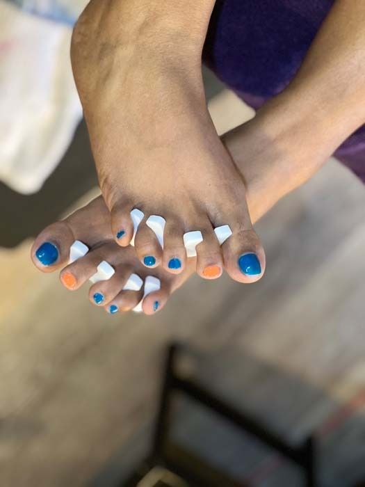 Blue and orange toenail pedicure with toe separators