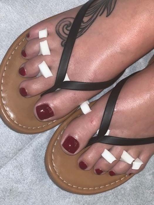 Deep red pedicure with black sandals
