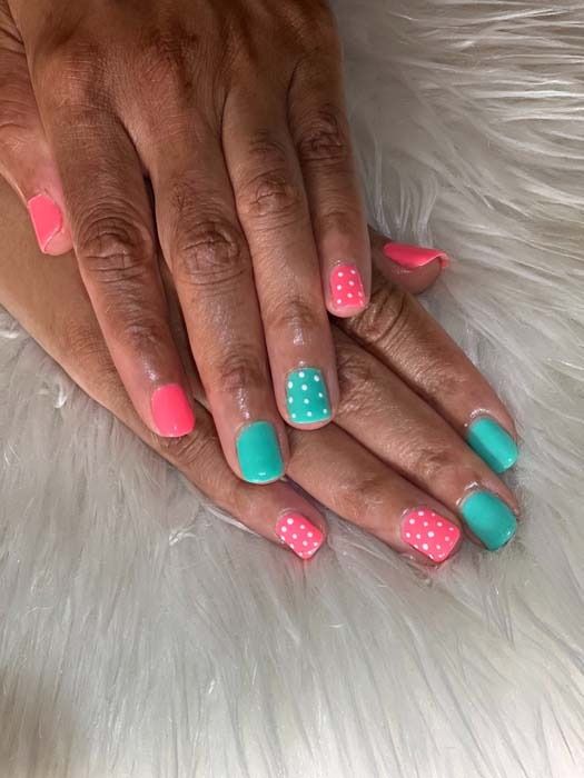 Coral pink and teal manicure with white polka dot nail art