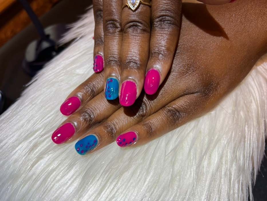 Pink manicure with blue nail art and rhinestone accents